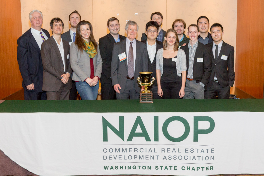 Runstad Center director Steve O'Connor (far left) congratulations the winning UW team (L-R): Craig Ratchford, Ryan Miller, Elizabeth Johnson, Jon Beem, site sponsor John Teutsch, Jin Seok Park, Nate Daum, Louisa Galassini, Aaron Lykken, Eric Hadden, Yifan Cui, Bo Peng.